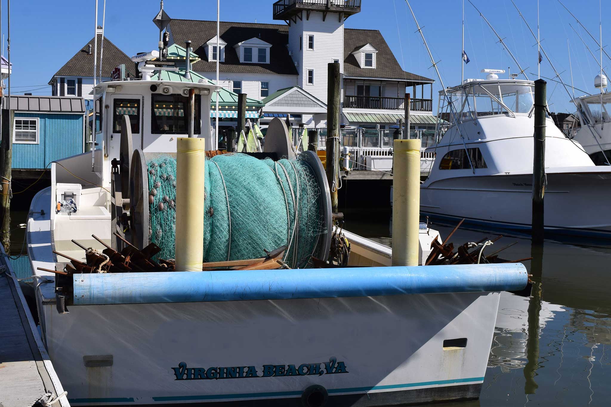 A fishing vessel at a dock, with the words Virginia Beach, VA on the stern