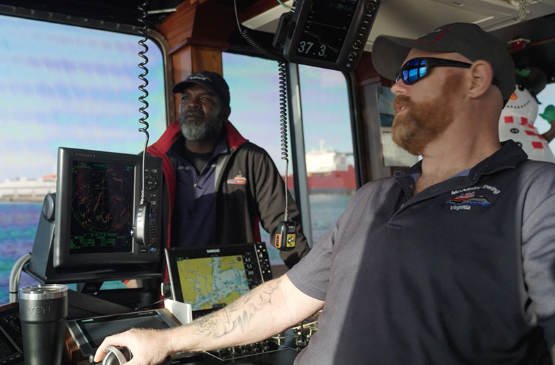 Two tugboat operators are in their vessel, engaged in work for the project