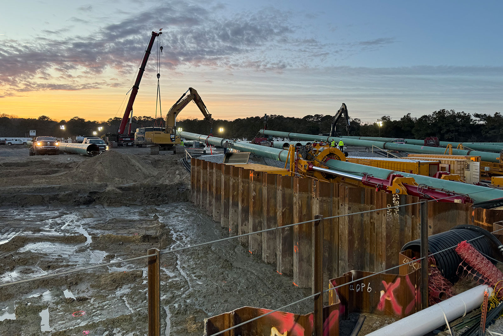 Construction with a crane and excavator takes place in the evening on the joint transition bay at SMR